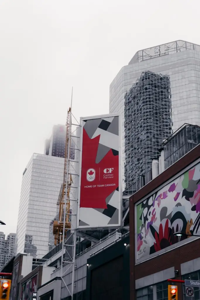 Cityscape featuring modern skyscrapers, a crane, and vibrant wall art in an urban street.