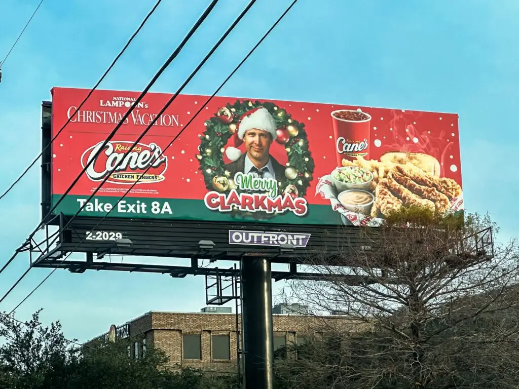 Festive holiday billboard featuring promotional content for a popular chicken restaurant.